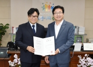 염태영 수원시장과 박지훈 지휘자가 위촉장을 들고 기념촬영을 하고 있다.