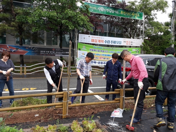 곡선동 주민, 단체원들이 마을텃밭에 그린커튼을 조성하고 있다.