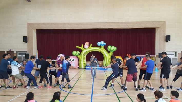 미니운동회에 줄다리기를 아버지와 아이들이 함께한팀씩  양쪽으로 나누어져 서로 줄다리기를 하고 있다.