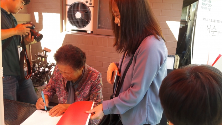 자신의 책에 사인하는 김선순 작가