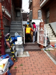 깔끄미사업단과 지역사회보장협의체 위원이 대상자의 집에서 쓰레기를 청소하고 있는 모습.