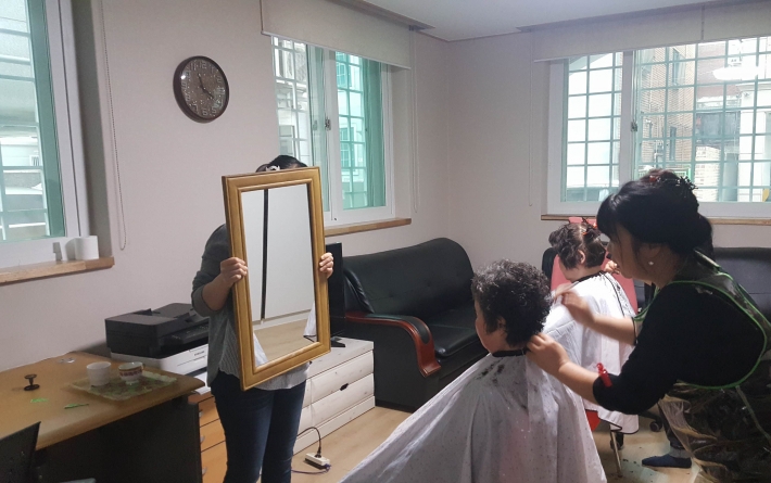 머털봉사단 회원들이 권선경로당에서 이·미용봉사 활동을 진행하고 있다.