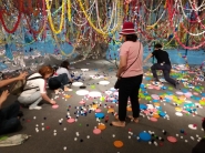 '코스모스& 만다라' 형형색색 프라스틱 뚜껑으로 만든 체험코너에서 병 뚜껑 던지기와 공기돌 놀이를 하고 있다. 
