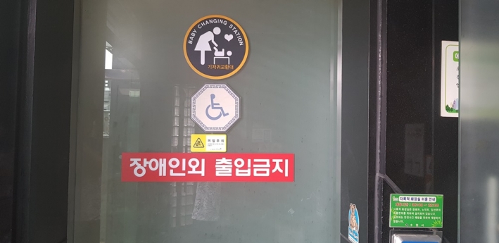 장애인용 화장실에는 장애인만 사용하라는 문구가 붙어 있다