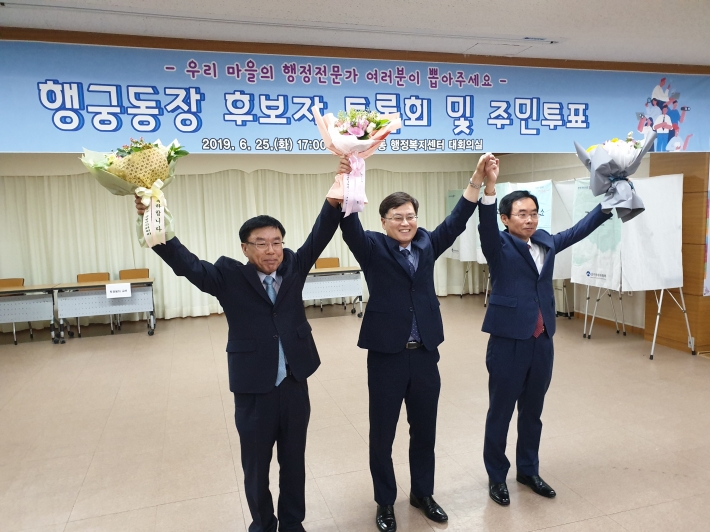행궁동장 대상자로 선발된 민효근 동장(가운데)과 함께 선거를 치른 후보들이 손을 맞잡고 있다. 