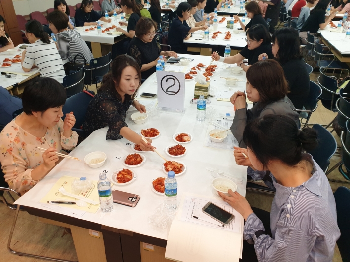 학생, 학부모 등으로 이뤄진 '맛 평가단'이 김치 맛을 평가하고 있다.  