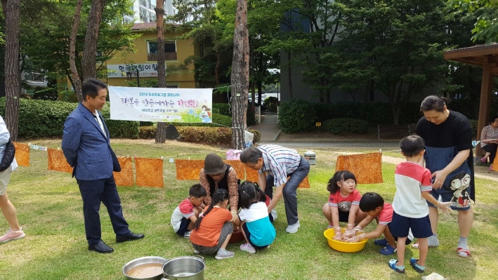 아이들이 천연염색에 손수건을 담가 염색하고 있다.