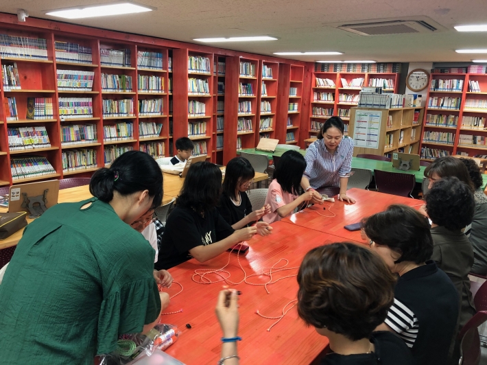 우만2동 새마을문고에서 어린이들이 팔찌를 만들고 있다.
