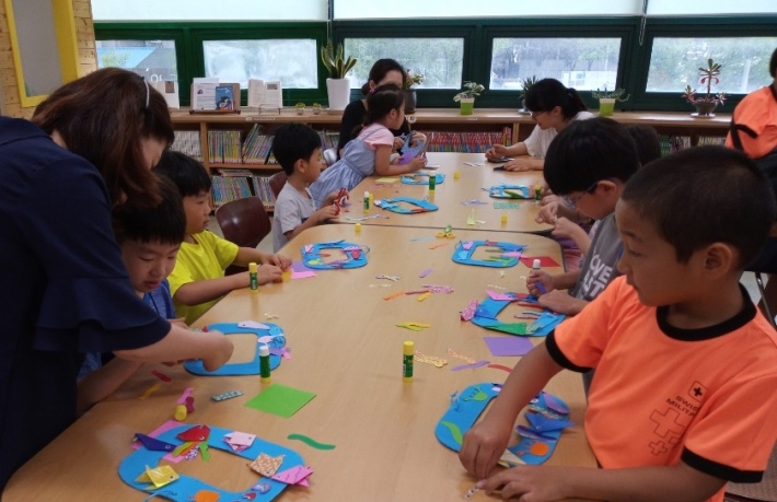 영통1동 새마을문고, 여름방학 특강에서 어린이들이 만들기를 하고 있다.