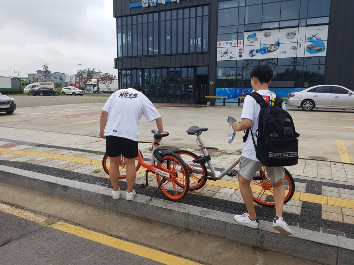 도로가에 방치되어있던 자전거를 한쪽으로 세워놓고 있는 체험단 학생들