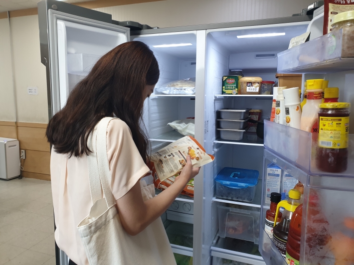 관내 지역아동센터 냉장고에서 식재료를 꺼내 유통기한 등을 확인하고 있다.