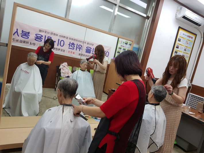 정자2동복지센터 미용봉사자들이 어르신들의 머리를 손질하고 있다. 