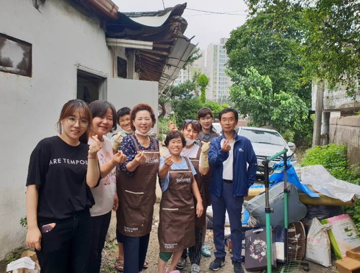 입북동 지역사회보장협의체 위원들이 독거어르신 주거환경 개선을 위해 청소봉사를 실시하고 다함께 미소지으며 기념사진을 찍고 있다.