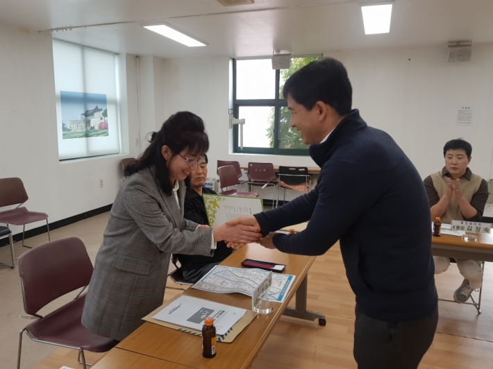 신임 9통장에게 위촉장을 전달하고 있다.