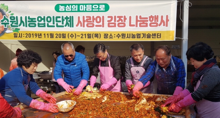 수원시농업기술센터에서 열린 '사랑의 김장 나눔 행사'에 참여한 수원시 농업인단체 임원들이 김치를 담그고 있다.