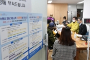 염태영 시장(오른쪽)이 20일 권선1동행정복지센터에서 재난기본소득을 신청하는 시민에게 방법을 안내하고 있다.