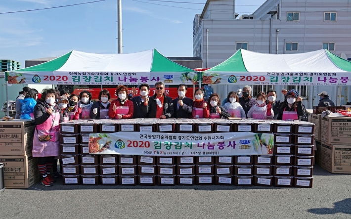 전국 농업기술자협회 수원시지회 회원들이 김장이 끝난 후 김장김치와 함께 단체로 찍은 사진 