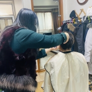 선지영 원장님이 대상자의 머리카락을 잘라주고 있다.