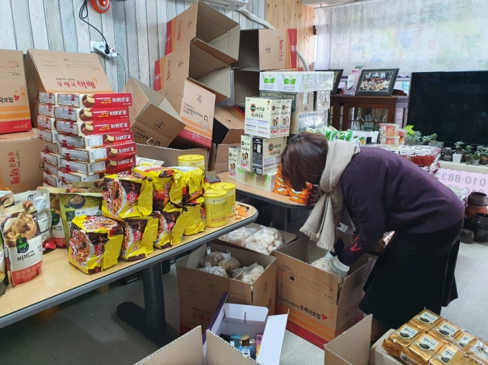 한 봉사자가 기부 불품을 분류하고 있다. 