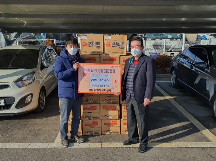 우측 첫번째 (주) 나누리 최찬식 대표가 서둔동에 라면 100박스를 기부하고 있다. 