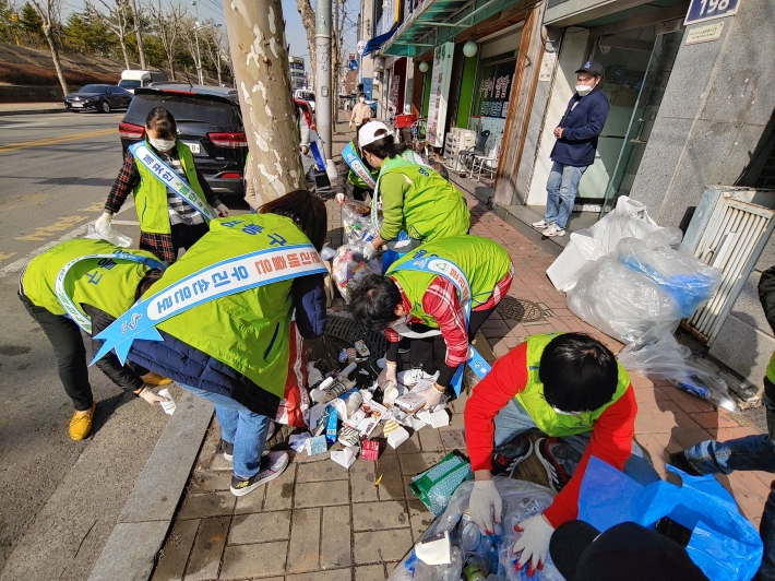 단체원들이 수거 거부된 쓰레기를 정리하고있다.