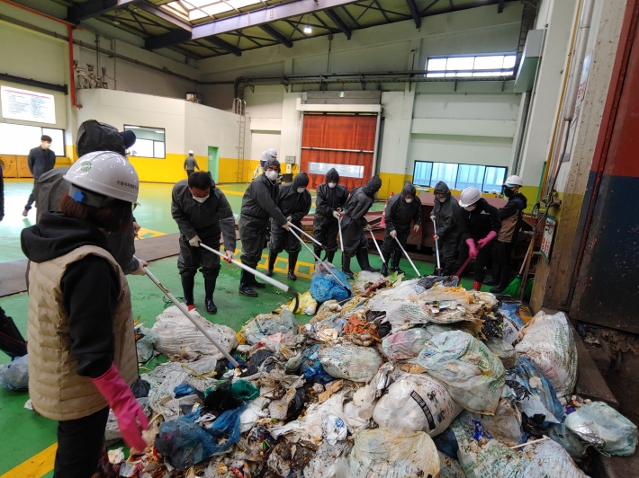 주민들이 자원회수시설에 반입되는 쓰레기 실태를 체험하고있다.
