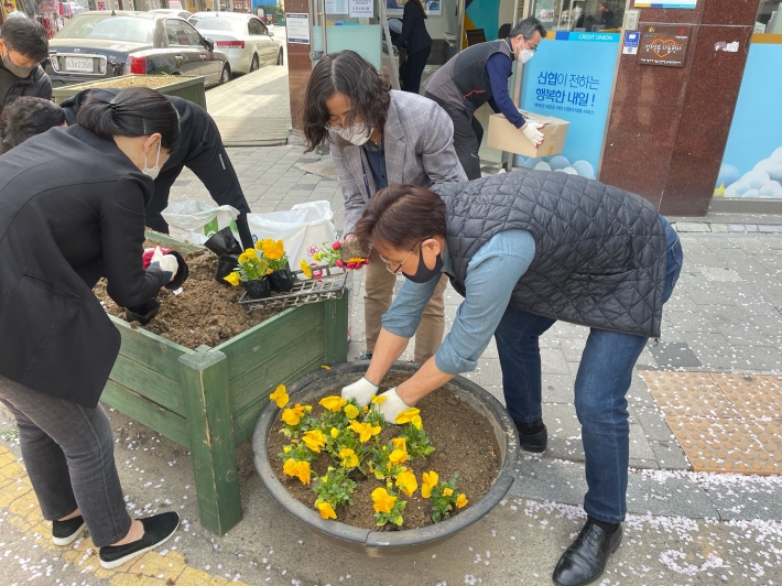 바르게살기위원회 회원들과 동 직원들이 꽃을 심고 있다
