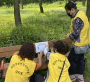 장안구 파장동 주민자치위원회원들이 공원 벤치를 소독하고 거리두기 홍보스티커를 부착하고 있다. 