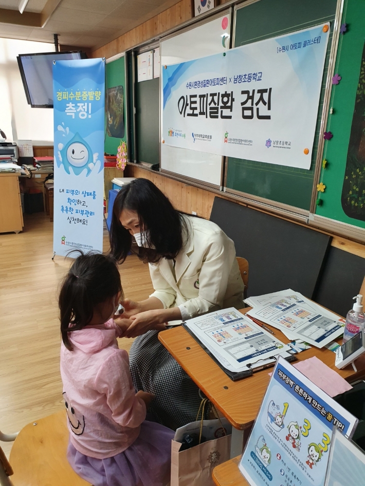 수원시환경성질환아토피센터 소속 간호사가 남창초등학교 학생의 피부 상태를 확인하고 있다. 