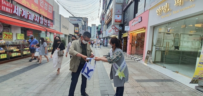  수원시여성단체협의회 회원이 시민에게 폐현수막으로 만든 에코백을 나눠주고 있다. 