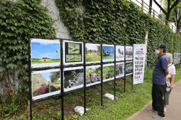수원천변에 설치된 「'렌즈속에 담긴 수원화성'세계문화유산 수원화성 사진전」을 관람하는 시민의 모습