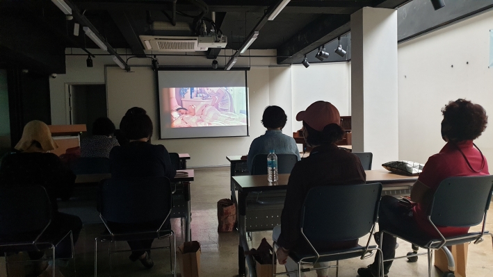 지동 주민이 창룡마을 창작센터 2층에서 추억의 영화를 관람하고 있다.