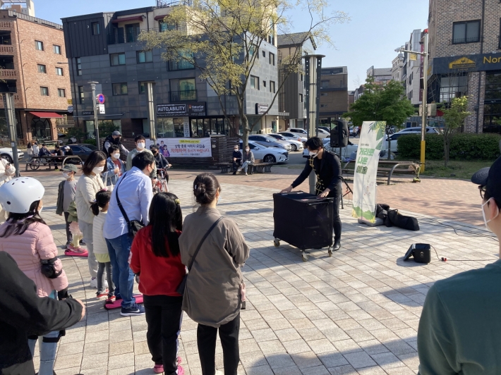 시민들이 '거리로 나온 예술' 프로그램으로 신동카페거리 일원에서 진행된 마술공연 버스킹을 지켜보고 있다.
