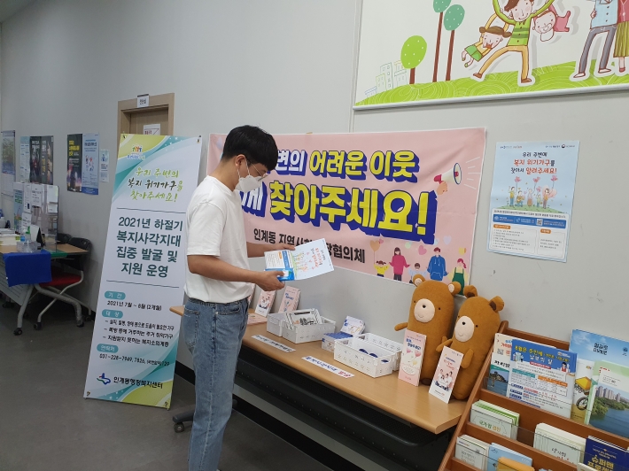 복지사각지대 홍보물을 살펴보는 주민