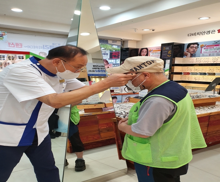 관내 저소득대상자가 안경점에 방문하여 돋보기를 맞추고 있는 장면