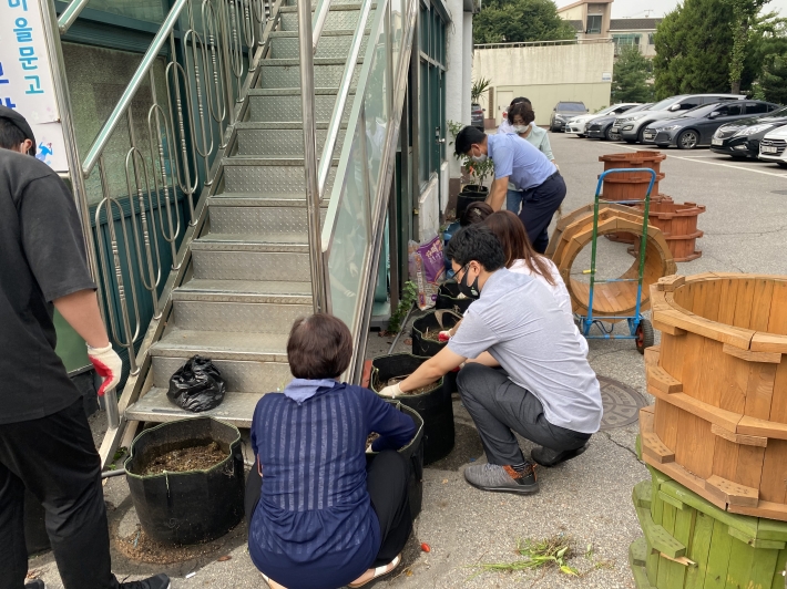 구운동 주민자치위원회 위원들이 화분에 배추를 심고 있다.