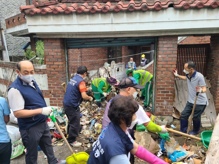 저장장애 가정을 청소 중인 환경관리원과 자원봉사 단체원