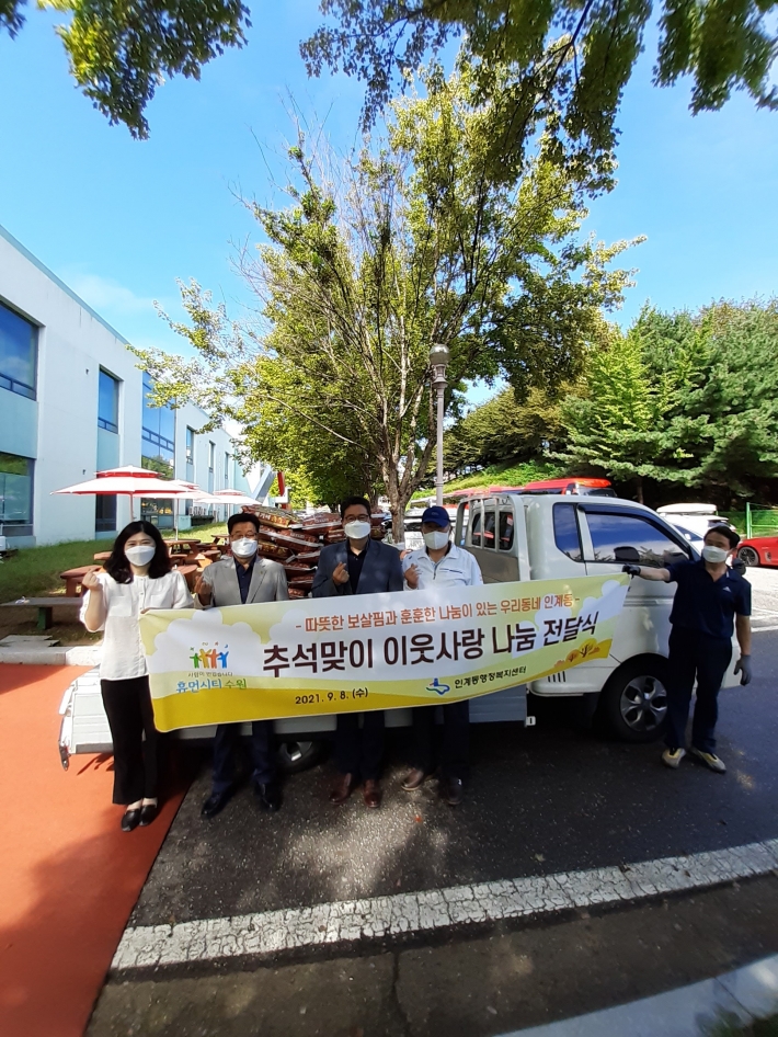 후원물품이 쌓인 트럭 앞에서 추석맞이 이웃돕기 물품 전달 관계자들 기념촬영 