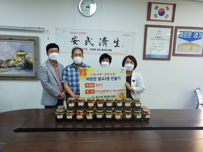 한국생활개선수원시연합회가 광교2동행정복지센터에 밑반찬을 기탁하는 모습.