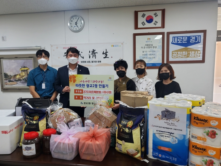 (사)경기도여성단체협의회 수원시지회가 다자녀가구 후원품을 광교2동 행정복지센터에 전달하고 있는모습.