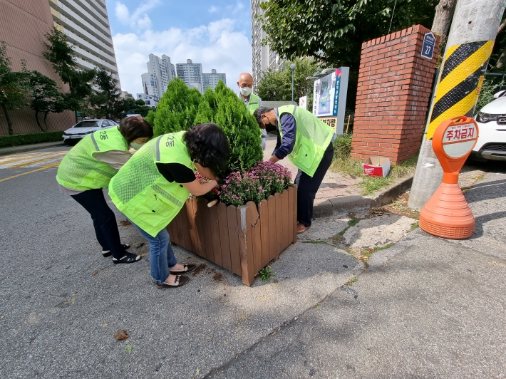 우만2동 단체장연합회 포함  동 직원이 계절 초화류를 식재하고 있다.