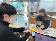 행정복지센터를 방문한 외국인이 쓰레기 분리배출 요령 설명을 듣고 있다.