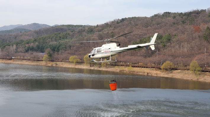 산불 진화용 임차헬기가 광교저수지 일원을 비행하는 모습