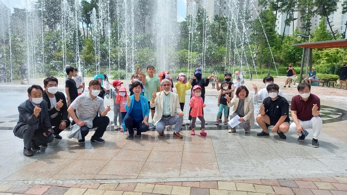 준공식 행사 후 국회의원, 시의원, 구청 녹지공원과 담당자, 시민 등이 어린아이들과 함께 사진을 찍고 있다. 