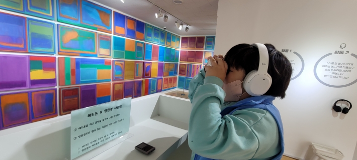 이다희 작가의 작품을 망원경으로 감상중인 어린이