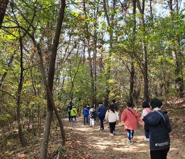 숲속 길 걷는 학생들