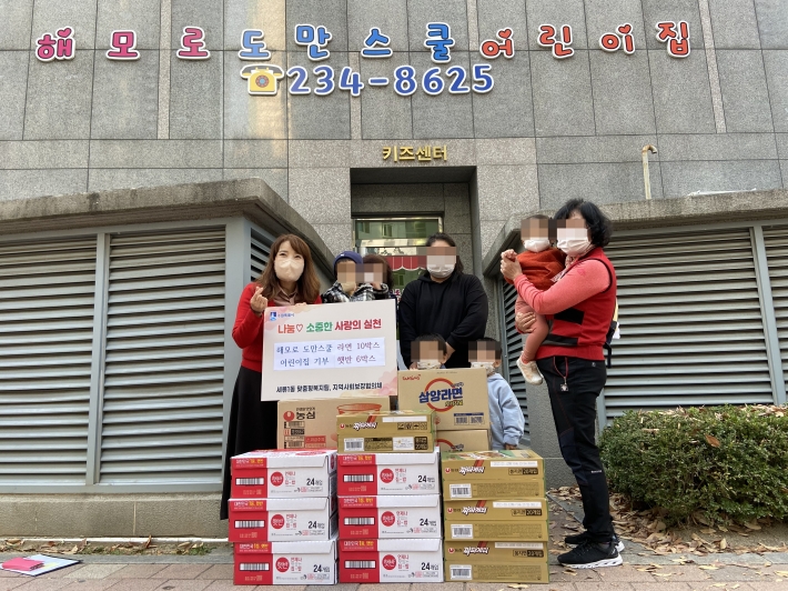 황혜경 도만스쿨 어린이집 원장과 학부모, 원생들이 기념촬영을 하고 있다.