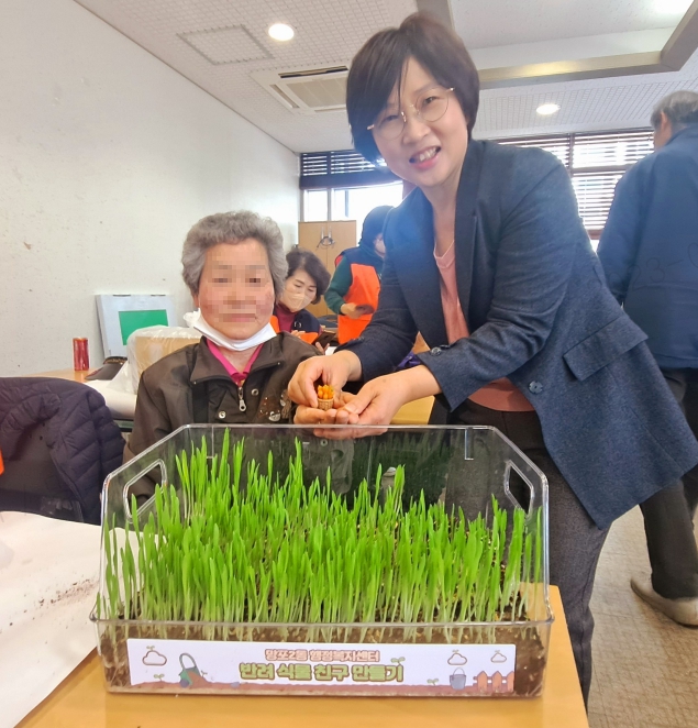 행사에 참여한 홀몸어르신이 만족해하며 함께 사진촬영하고 있다. 