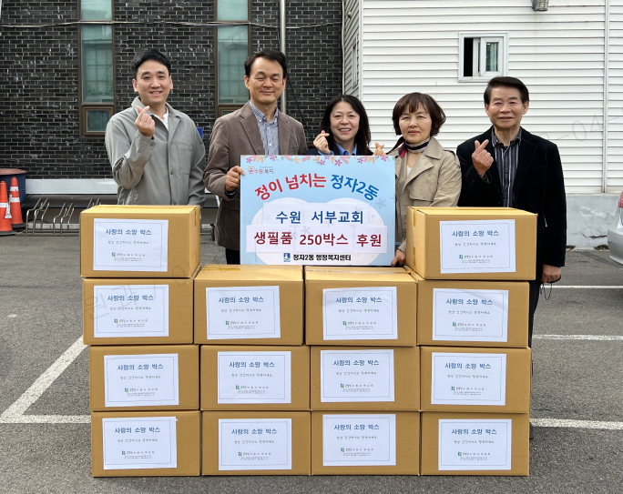 수원 서부교회 앞에서 이준호 목사와 정혜인 정자2동장 등 관계자들이 사랑의 소망 박스를 앞에 두고 포즈를 취하고 있다. 