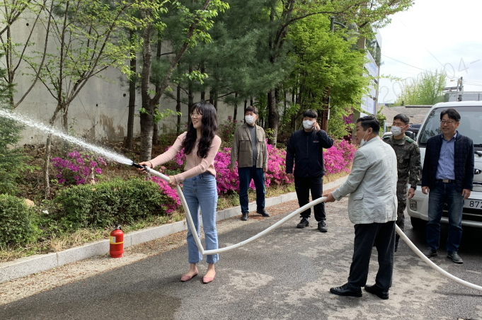 올바른 소화전 사용법을 실습하고 있다.